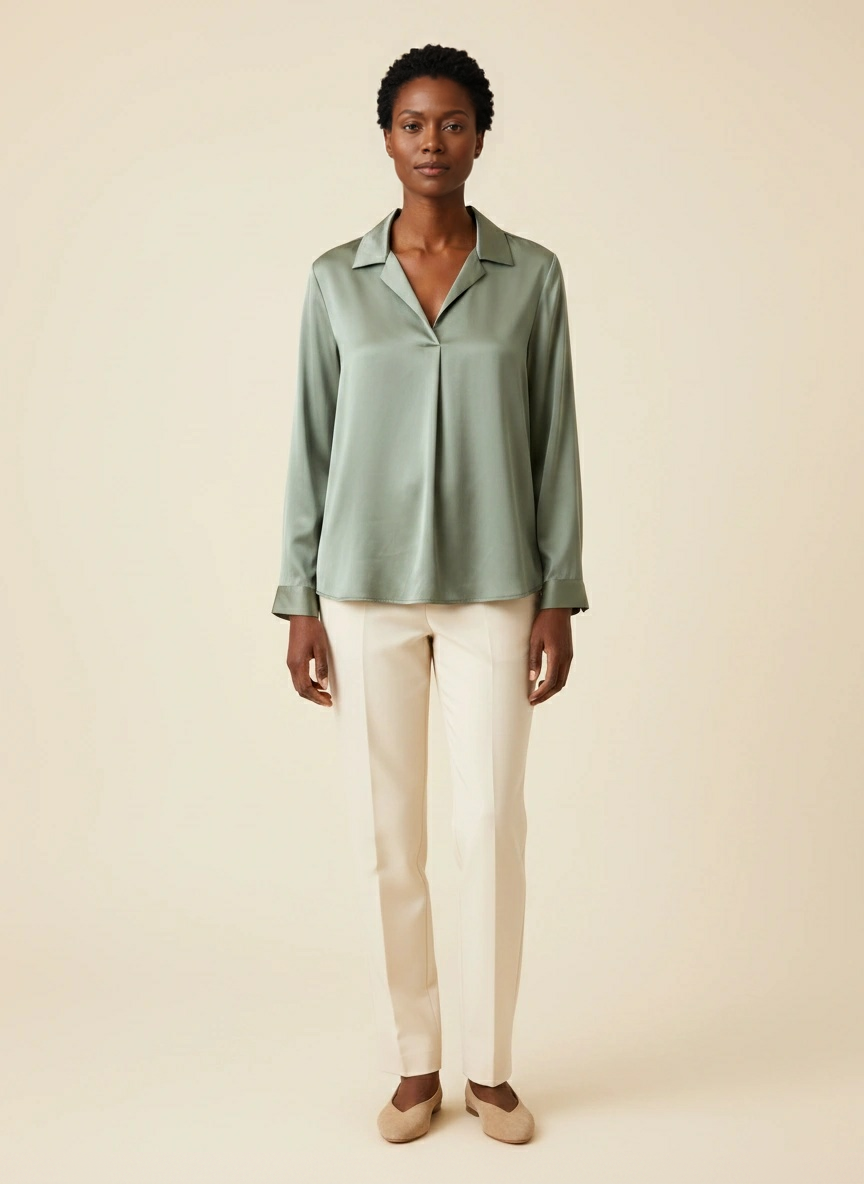Hetzelfde exclusieve model met de saliegroene blouse, neutraal in een lichte studio