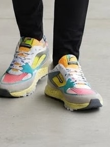 Detailopname: mannelijk model draagt de kleurrijke sneakers, van dichtbij