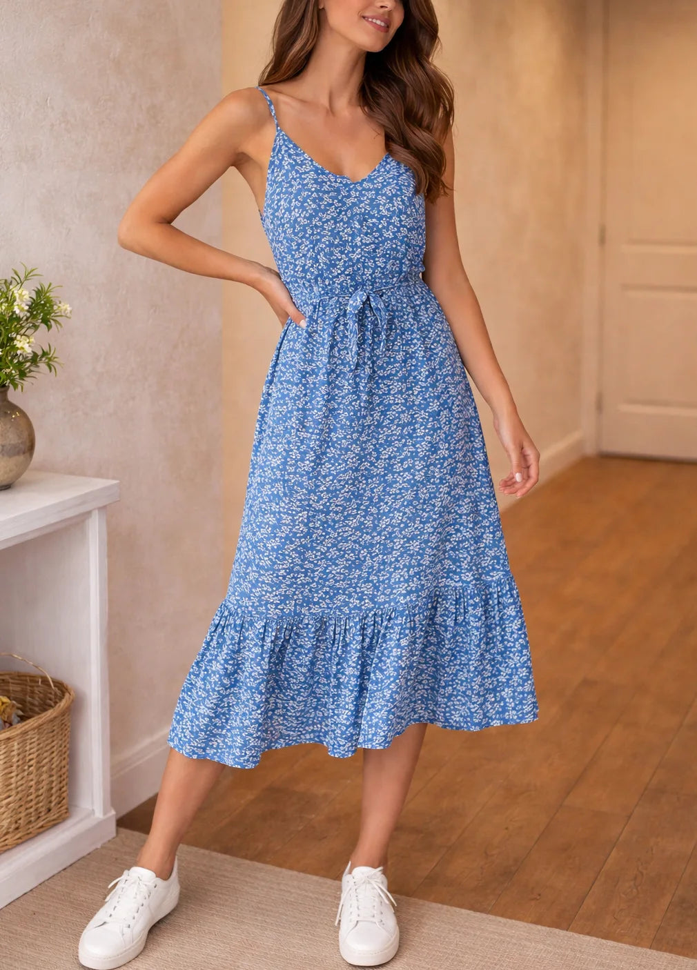 Bestaande productfoto van een webshop: een model draagt een blauwe jurk met bloemendessin