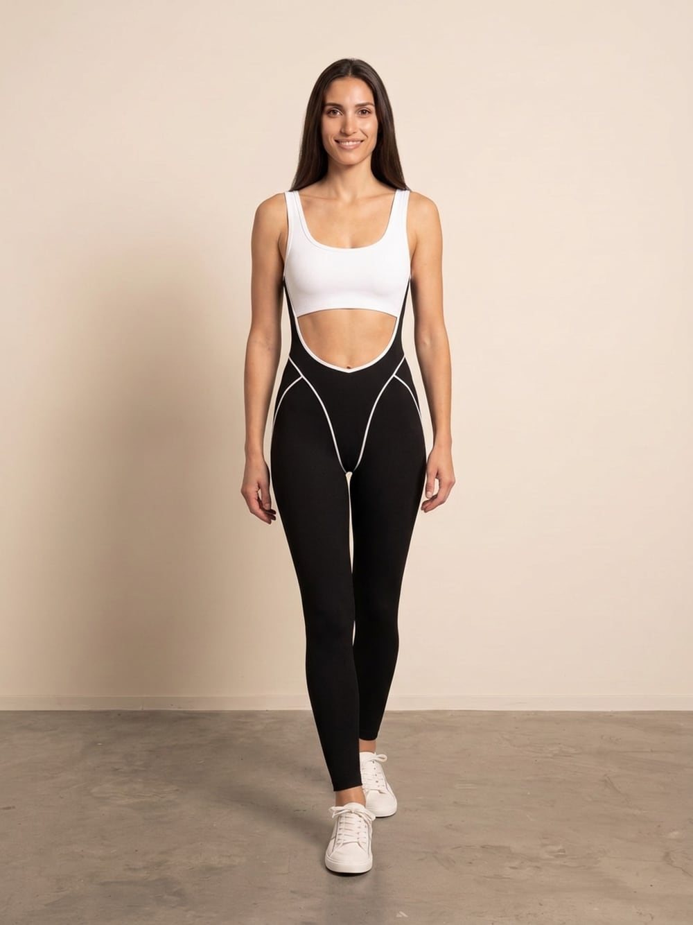 Sara draagt een jumpsuit met witte top en zwarte pijpen met witte naden, recht van voren, glimlachend