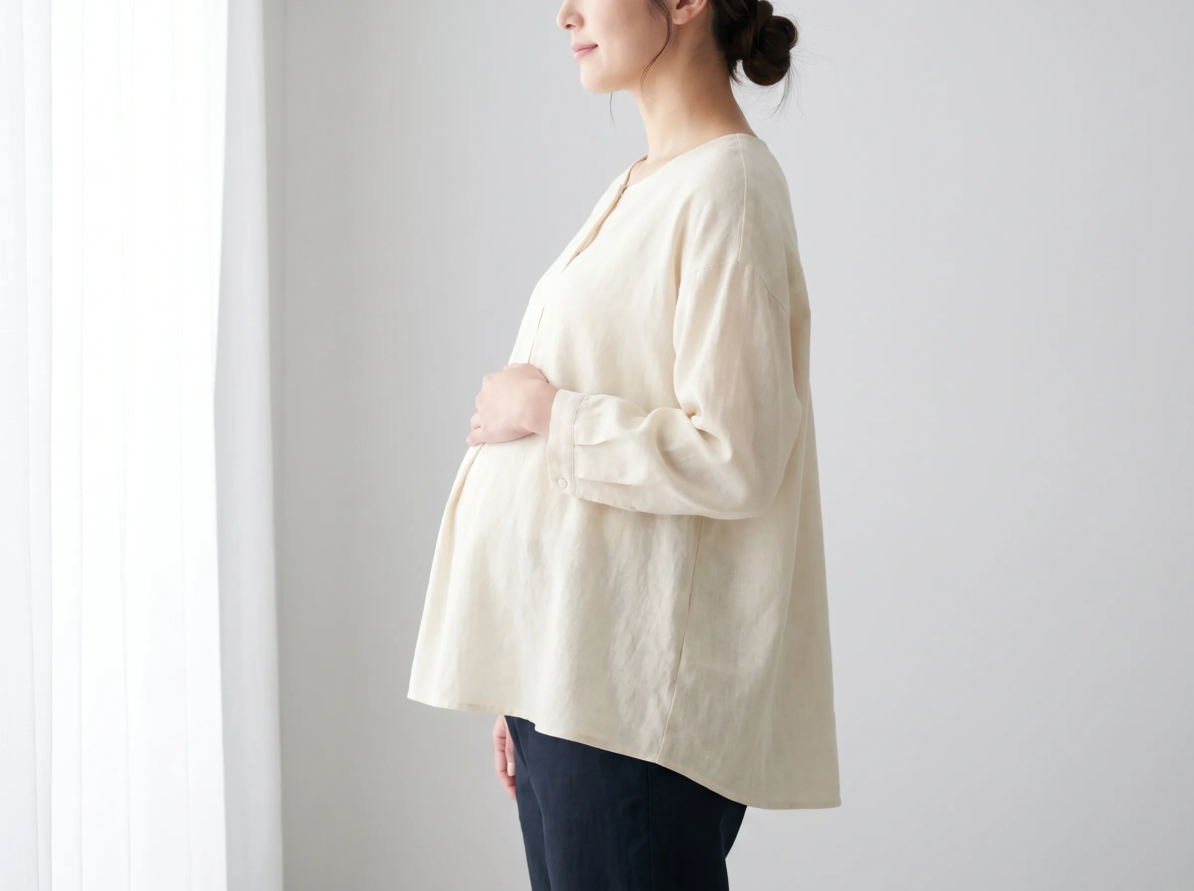 Zijaanzicht van een zwangerschapsblouse gedragen door een zwanger model in een fotostudio